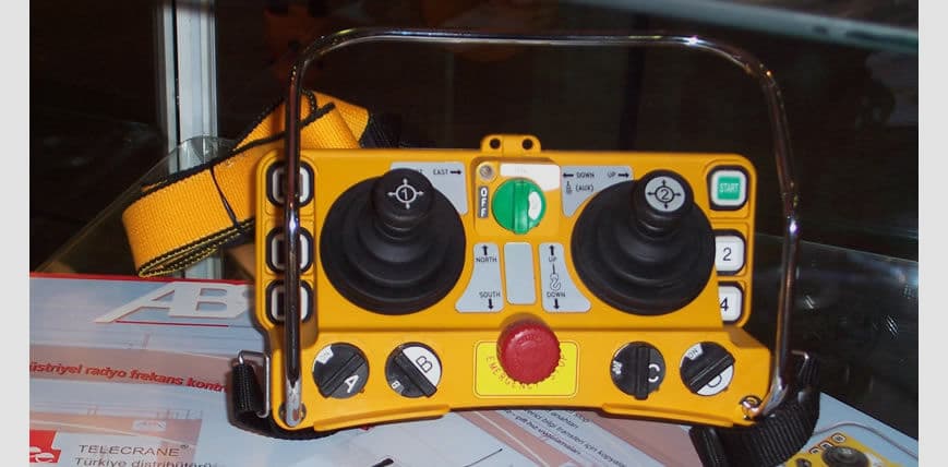 Radio remote control transmitter for a crane, one of the components supplied and replaced on service calls